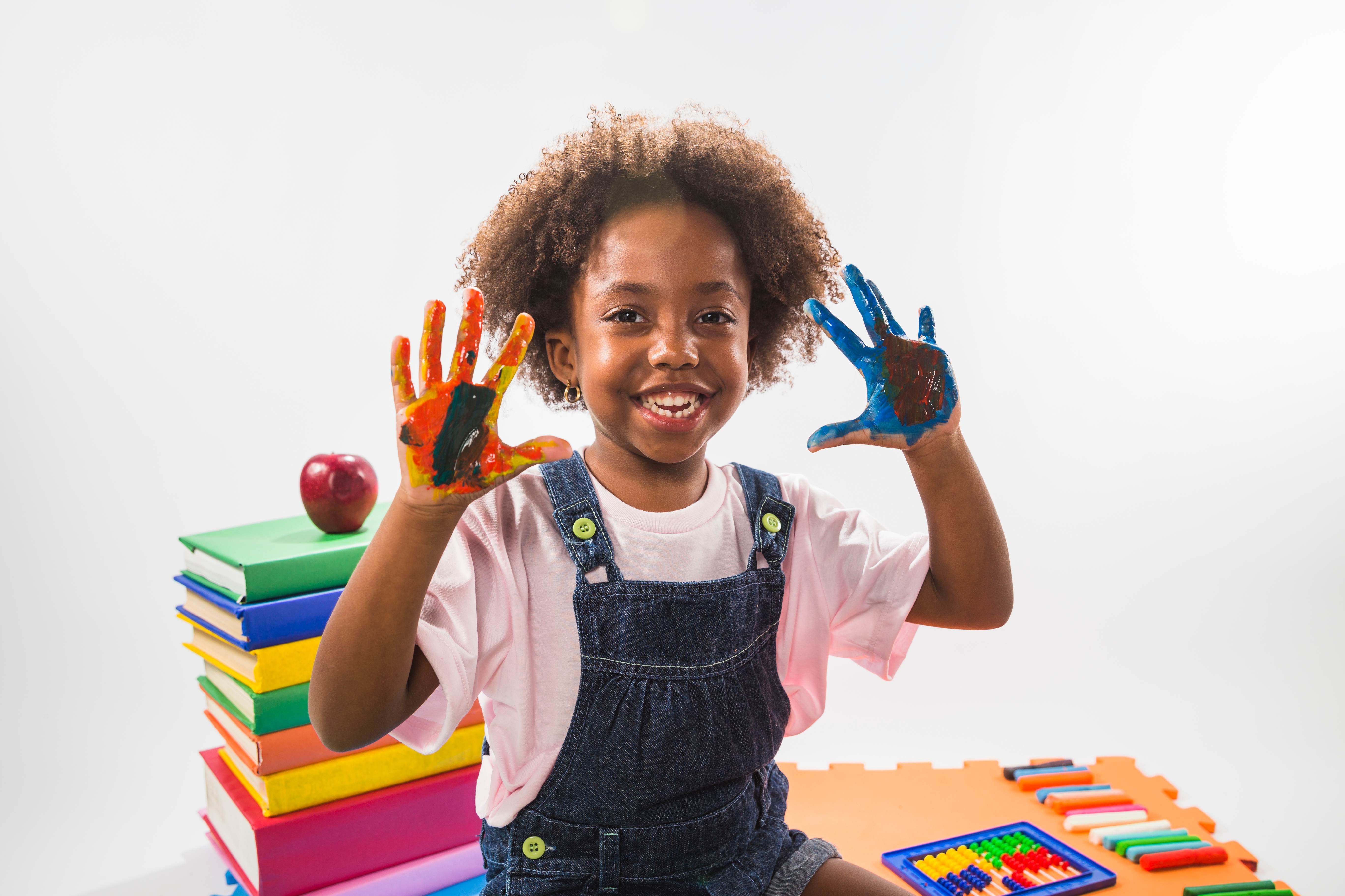 Child with painted hands showing creativity and joy